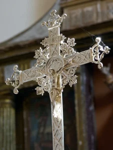 Imagen del altar en el que se ve la cruz y cuadros del interior de la iglesia de Villacil, La Sobarriba