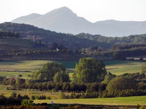 Montaña con un pueblo y prados verdes en la Ruta A de La Sobarriba (León)