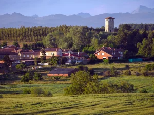 Pueblo con torre y montañas al fondo en la Ruta A de La Sobarriba (León)