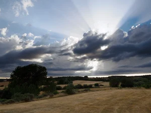 Rayos de sol entre nubes sobre el campo en la Ruta D de La Sobarriba (León)
