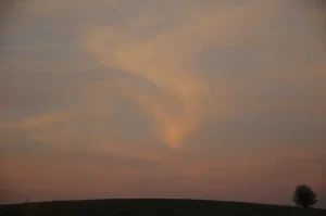 Nubes teñidas de rosa al atardecer sobre los campos en la comarca de la Sobarriba (León)